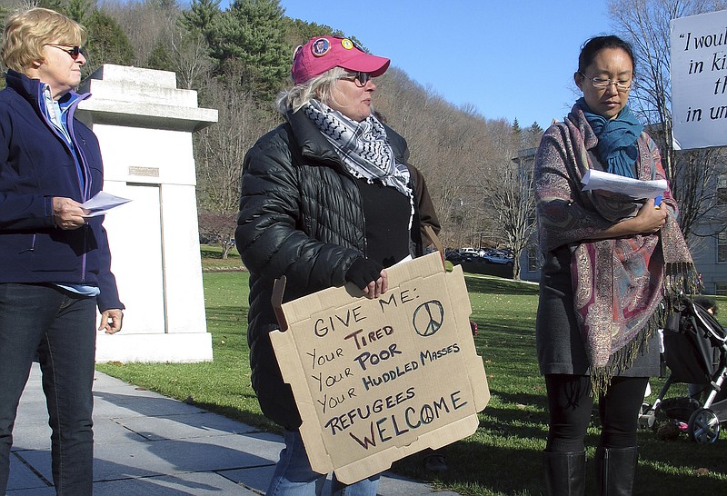 Crystal Zevon, center, holds a sign on Friday Nov. 20 at the Statehouse in Montpelier, Vt., at a rally where she supported bringing Syrian refugees to the state. About a half-dozen people opposed to bringing Syrians attended while about 40 people supported the possibility of bringing refugees to Vermont. Gov. Peter Shumlin has said he favors bring refugees to the state who have been thoroughly vetted. (AP Photos/Wilson Ring)