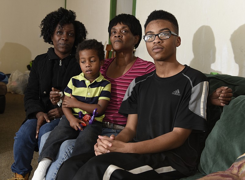 Staff Photo by John Rawlston Family members of Monica McMillon, killed inside her Alton Park home when someone shot at her house from the street on Tuesday night, gather in the home of her mother Brenda McMillon, second from right, on Wednesday, Nov. 25, 2015, in Chattanooga, Tenn. Sitting with her are the victim's sister, Amanda Crowder, left, and two of the victim's three children, Matthew McMillon, left, and Malik Jones.