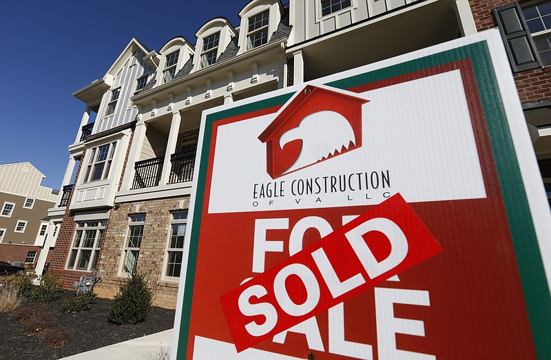 
              FILE - In this Jan. 8, 2015, file photo, a sign with a sold sticker is posted in front of a row of new town homes in Richmond, Va. The Commerce Department reports on sales of new homes in October, on Wednesday, Nov. 25, 2015. (AP Photo/Steve Helber, File)
            