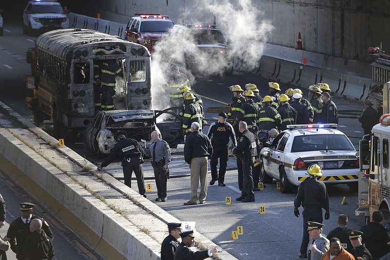 
              Investigators and firefighters work the scene of a fire and shooting Tuesday, Nov. 24, 2015, in Philadelphia. A Pennsylvania state police trooper has been shot in the shoulder after a fiery crash along Interstate 676. (AP Photo/Matt Rourke)
            