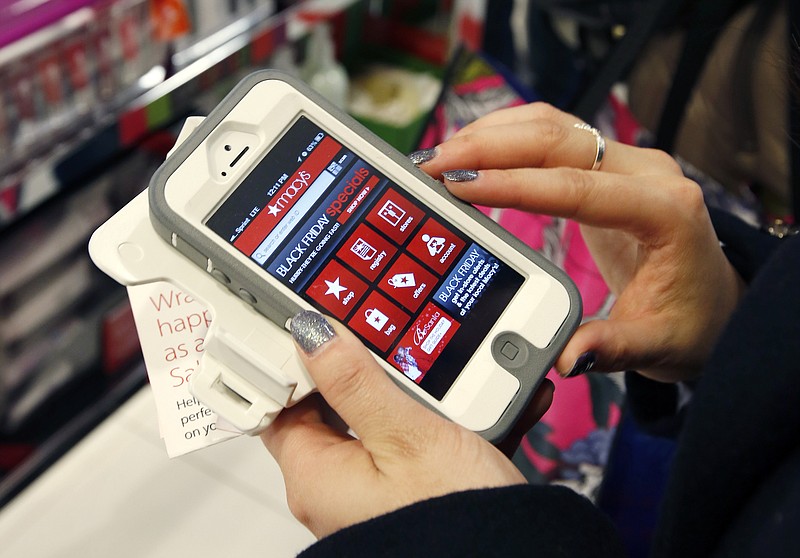 
              FILE - In this Friday, Nov. 23, 2012, file photo, Tashalee Rodriguez, of Boston, uses a smartphone app while shopping at Macy's in downtown Boston. For the first time, analysts predict more than half of online traffic to retailer sites will come from smartphones than desktops during the busy Black Friday holiday shopping weekend. And though it’s still a small fraction of online revenue, mobile sales are jumping too. Larger phone sizes, improved retailer apps, more online deals and shoppers’ increasing comfort with shopping online are driving the trend. (AP Photo/Michael Dwyer, File)
            