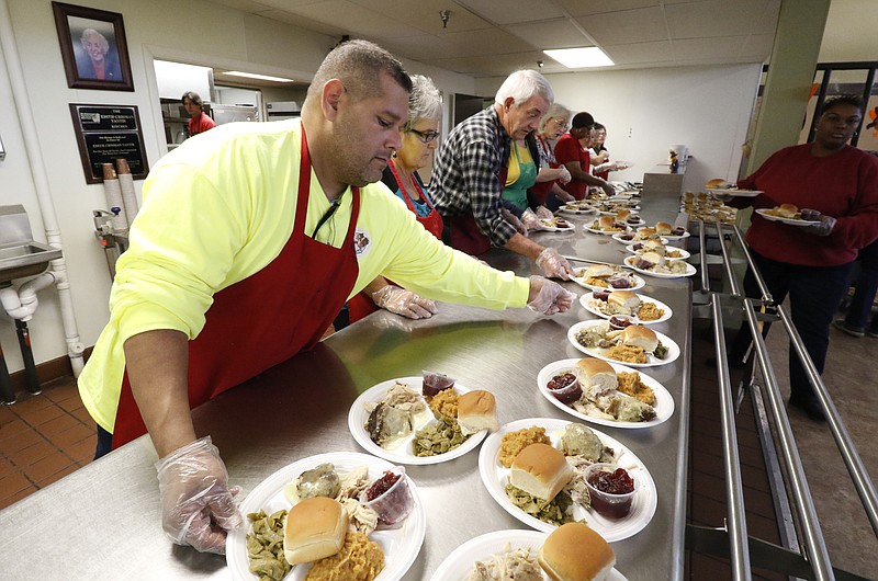 Volunteer David Reyna prepares Thanksgiving meals for the homeless while at the Chattanooga Community Kitchen on Thursday, Nov. 26, 2015. 