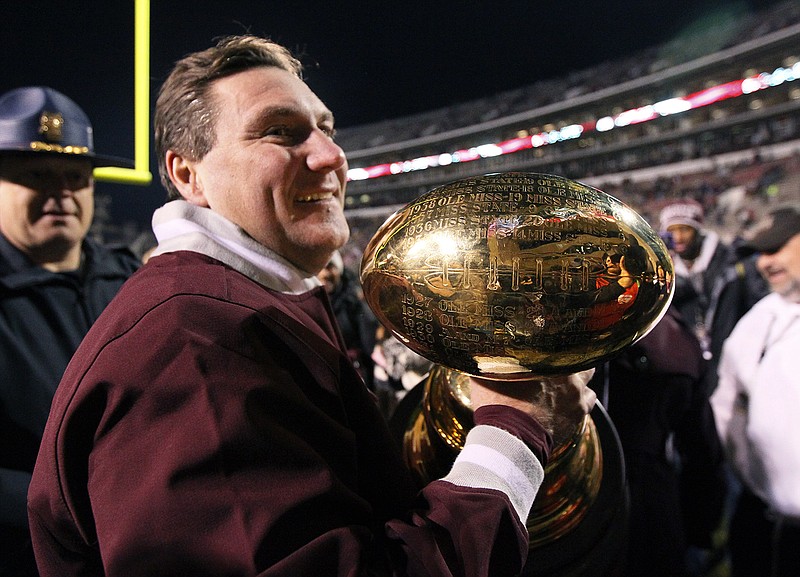 FILE - In this Nov. 28, 2013, file photo, Mississippi State coach Dan Mullen carries the Egg Bowl trophy after his team beat Mississippi 17-10 in overtime in an NCAA college football game, in Starkville, Miss. For the second straight year and just the sixth time in the rivalry's history, No. 19 Mississippi and No. 23 Mississippi State will both be nationally ranked for the Egg Bowl. (AP Photo/Rogelio V. Solis, File)