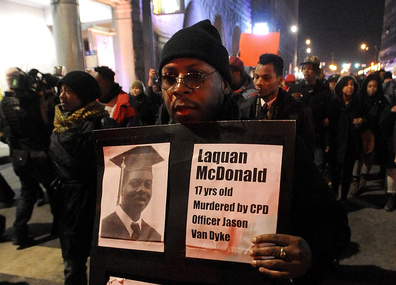 
              FILE - In this Tuesday, Nov. 24, 2015, file photo, a protester holds a sign as people rally for 17-year-old Laquan McDonald, who was shot 16 times by Chicago Police Department Officer Jason Van Dyke in Chicago. McDonald, whose name demonstrators are shouting as they march the streets and plan to shut down the city’s glitziest shopping corridor on Friday, lived a troubled life full of disadvantages and at least one previous brush with the law. (AP Photo/Paul Beaty, File)
            