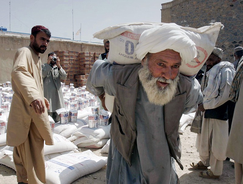 
              FILE - In this May 10, 2009, file photo, an Afghan man carries a sack of wheat distributed to poor displaced families of Helmand province in the city of Kandahar province south of Kabul, Afghanistan. With Washington set to send billions of dollars in fresh aid to Afghanistan despite the military drawdown, the U.S. official in charge of auditing assistance programs says “it’s not too late” to address the fraud and mismanagement that has bedeviled the 14-year effort to rebuild the country. (AP Photo/Allauddin Khan, File)
            