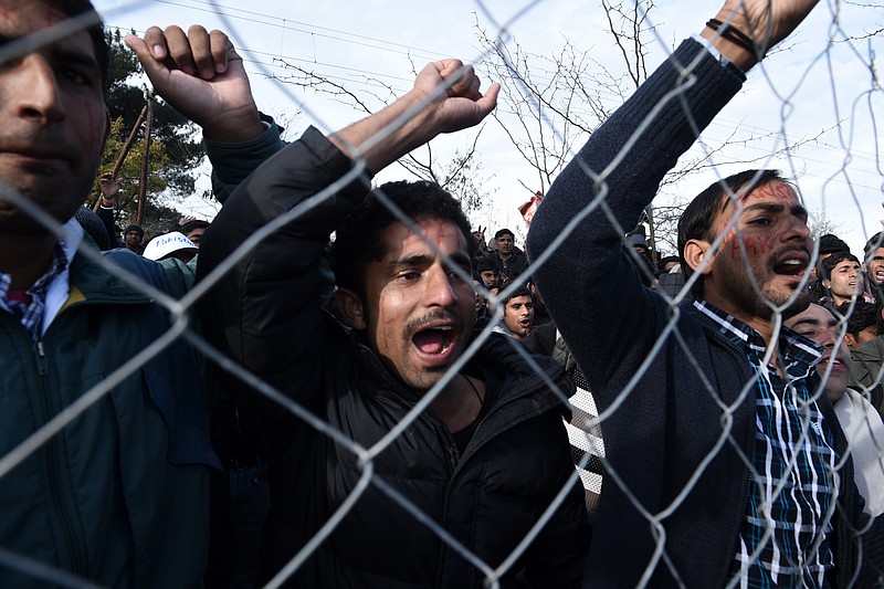 
              Pakistani migrants demonstrate behind a fence as they demand to be allowed to pass the Greek-Macedonian border, near the northern Greek village of Idomeni, Thursday, Nov. 26, 2015. Migrants stranded at the border have been protesting for days, as several of them have started a hunger strike, after Macedonia and other Balkan countries toughen criteria for migrants and asylum seekers hoping to travel across the region to northern Europe. (AP Photo/Giannis Papanikos)
            