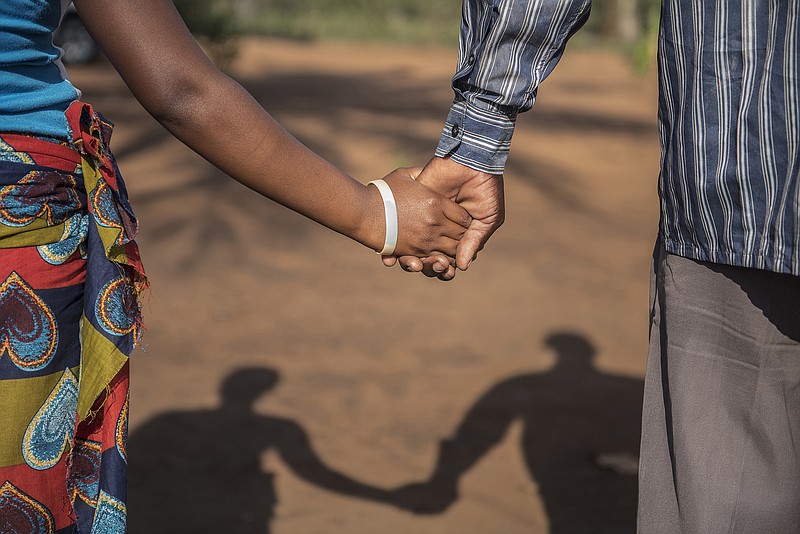 
              In this photo taken Wednesday, Nov. 18, 2015 a 15-year-old pregnant girl holds hands with her 20-year-old husband-to-be in Guibombo, some 40 kilometers from the city of Inhambane, Mozambique. In Mozambique there are no laws preventing child marriages and existing child protection laws offer loopholes. If a community decides that a girl is to be married in a traditional ceremony, with or without her consent, lawmakers are powerless to intervene. (AP Photo/Shiraaz Mohamed)
            
