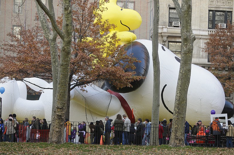 
              People pass the Snoopy with Woodstock balloon as preparations continue for the Macy's Thanksgiving Day Parade Wednesday, Nov. 25, 2015, in New York. (AP Photo/Frank Franklin II)
            