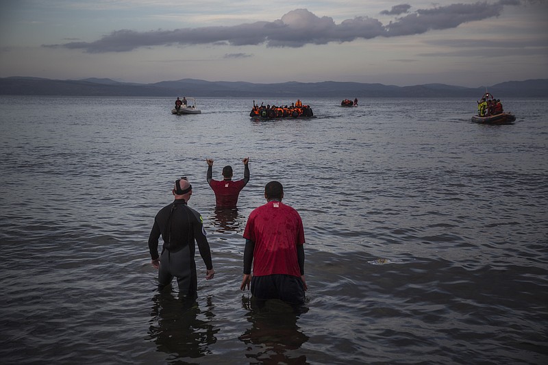 
              Volunteers help refugees approaching the coast of the northeastern Greek island of Lesbos onboard two dinghies after crossing the Aegean from a the Turkey's coast, on Tuesday, Nov. 24, 2015. Several European countries, including EU members Slovenia and Croatia and non-members Serbia and Macedonia, have declared they will only allow "war-zone refugees" from Afghanistan, Iraq and Syria to transit through their countries on their way to central and northern Europe. (AP Photo/Santi Palacios)
            