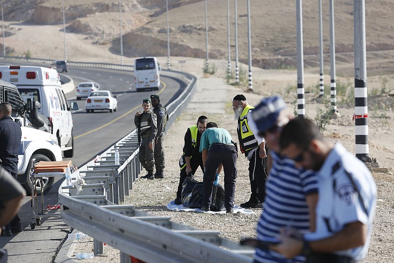 
              Israeli emergency services lift the body of an alleged Palestinian attacker near Kfar Adumim settlement in the West Bank, Friday, Nov 27, 2015. Israeli officials say a Palestinian was shot and killed after ramming his car into a group of Israelis, injuring soldiers in the attack. (AP Photo/ Nasser Shiyoukhi)
            