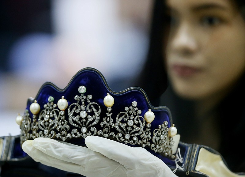 
              Katrina Camille Pena of the Presidential Commission on Good Government holds a set of jewelry from the so-called Hawaii Collection, one of three sets of the Marcos Jewelry Collection, during appraisal by Sotheby's at the Central Bank of the Philippines Friday, Nov. 27, 2015 in Manila, Philippines. The Hawaii Collection was seized by the US Bureau of Customs upon the Marcos' arrival in Hawaii in 1986 and is now under the custody of the Philippine Commission on Good Government or PCGG. The appraisal was made to determine its current value which was put at $5 to $7 million dollars in 1988 and 1991.(AP Photo/Bullit Marquez)
            