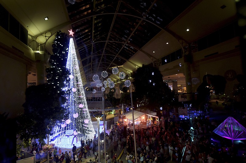 
              In this Friday, Nov. 27, 2015 photo, people gather to observe a Guinness World Records attempt for the most lights on an artificial Christmas tree in Canberra, Australia. Australian David Richards set his third Christmas-themed world record in as many years Friday by illuminating a tree in downtown Canberra with 518,838 twinkling lights. Guinness World Records confirmed that Richards had broken the record for the most lights on an artificial Christmas tree that had been held for five years by Universal Studios Japan in Osaka. (Lukas Coch/AAP Via AP) AUSTRALIA OUT, NEW ZEALAND OUT, PAPUA NEW GUINEA OUT, SOUTH PACIFIC OUT, NO SALES, NO ARCHIVES
            