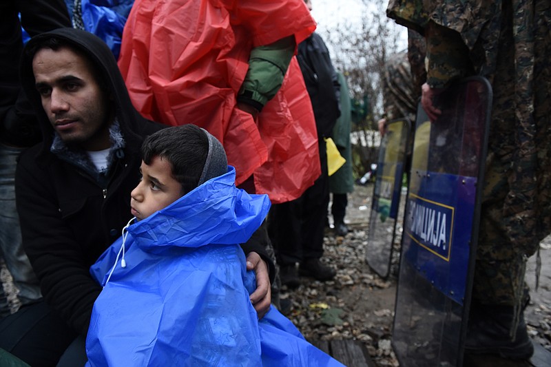 
              An Iranian migrant and his son sit in no man's land demanding to be allowed to pass the Greek-Macedonian border, near the northern Greek village of Idomeni, on Friday, Nov. 27, 2015. Macedonia toughened rules for crossings earlier this month, in the wake of the deadly Paris attacks, restricting access to citizens from countries typically granted asylum in Europe, including Syria and Afghanistan. (AP Photo/Giannis Papanikos)
            