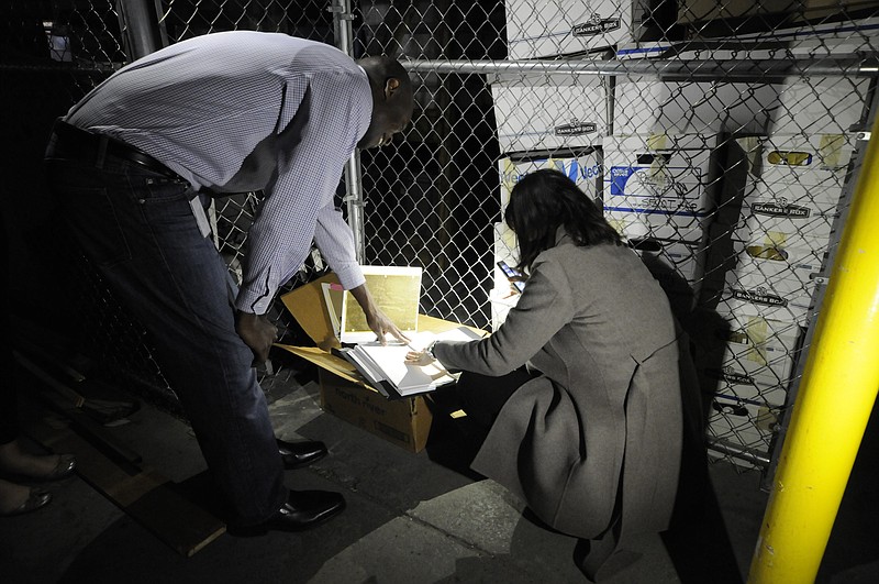 City Attorney Wade Hinton, left, and Communications Director Lacie Stone take a look at old city records that include and executive board meeting of the Community Development Corporation in storage in a warehouse on East Main Street recently.
