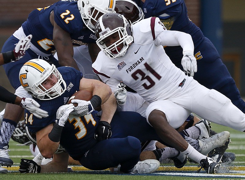 UTC running back Derrick Craine falls to the ground ahead of Fordham defensive back Caleb Ham, Craine's high school teammate, in the second half of the Mocs' 50-20 win.