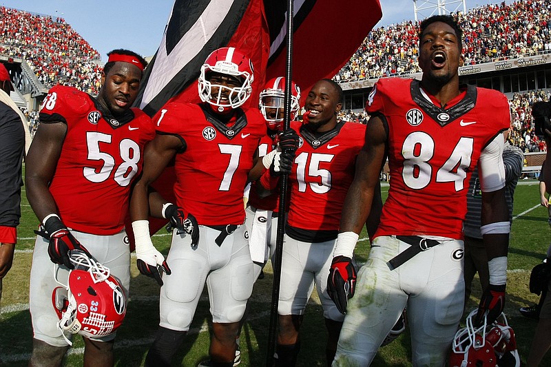 Georgia defensive players Sterling Bailey (58), Lorenzo Carter (7), Davin Bellamy, D'Andre Walker (15) and Leonard Floyd (84) celebrate at midfield after an NCAA college football game against Georgia Tech Saturday, Nov. 28, 2015, in Atlanta, Ga. Georgia won 13-7. (AP Photo/Brett Davis)