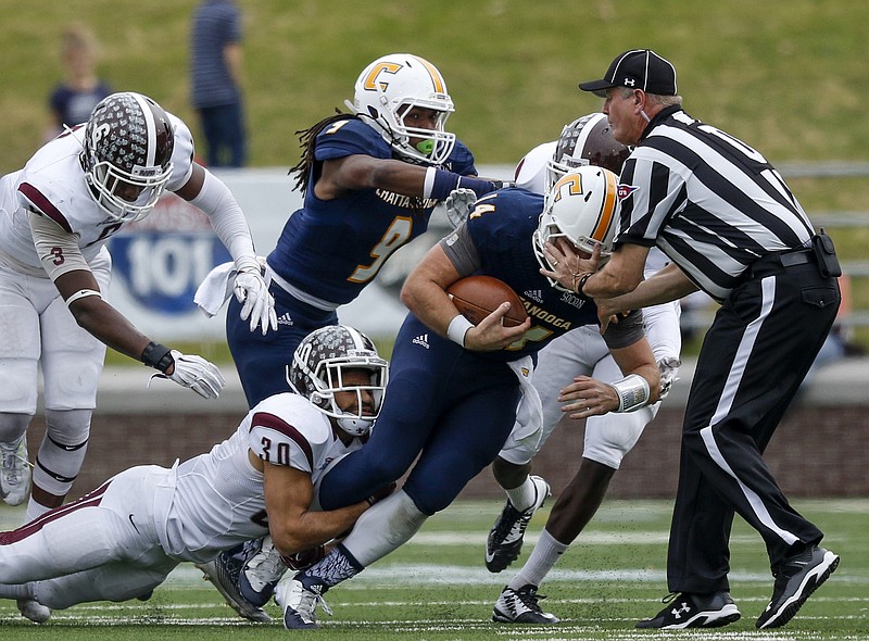 UTC quarterback Jacob Huesman hits umpire Bill Ballard as he is tackled by Fordham defensive back J.Q. Bowers in the first half of the Mocs' FCS playoff football game against Fordham at Finley Stadium on Saturday, Nov. 28, 2015, in Chattanooga, Tenn.