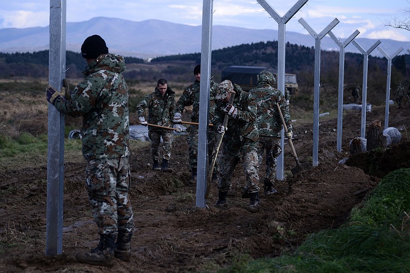 
              Macedonian army build a border fence to prevent illegal crossings by migrants, in the Greek-Macedonian border near the Greek village of Idomeni on Saturday, Nov. 28, 2015. Macedonia toughened rules for crossings earlier this month, in the wake of the deadly Paris attacks, restricting access to citizens from countries typically granted asylum in Europe, including Syria and Afghanistan. (AP Photo/Giannis Papanikos)
            