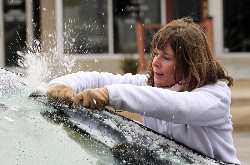 
              Krystal Wright scrapes ice from her car's windshield Friday, Nov. 27, 2015 in Wichita, Kan. The winter weather left a layer of ice on roads and cars early Friday morning after a heavy rain on Thanksgiving day that set a record with over 2 inches of rain. Brian Corn/The Wichita Eagle via AP)
            