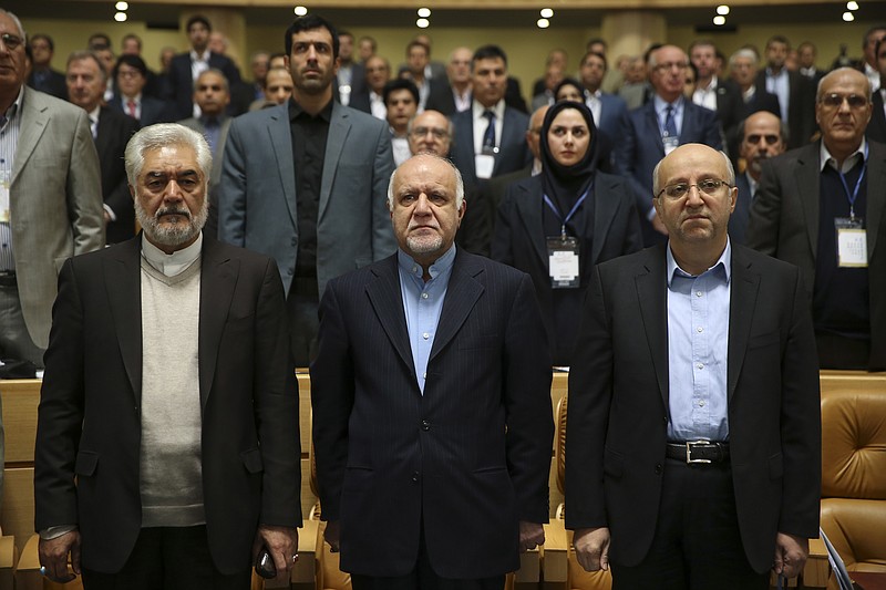 
              Iran's Oil Minister Bijan Zanganeh, center, Managing Director of National Iranian Oil Company, Roknoddin Javadi, right, head of parliament's energy committee Ali Marvi, left, and participants listen to Iran's national anthem during opening ceremony of Iran Petroleum Contracts Conference in Tehran, Iran, Saturday, Nov. 28, 2015. Iran has unveiled a new model of oil contracts aimed at attracting foreign investment once sanctions are lifted under a landmark nuclear deal reached earlier this year. (AP Photo/Vahid Salemi)
            