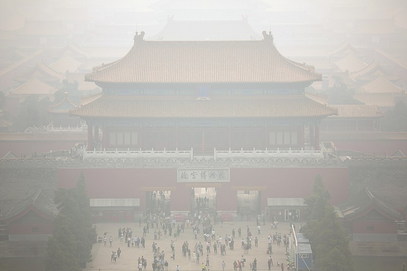 In this Oct. 7, 2015 photo, haze envelops the Forbidden City as seen from nearby hilltop park on a polluted day in Beijing. China's polluted air is still largely hazardous to health, and officials won't even guess when air will finally reach levels that could be considered healthy. But some experts, officials and observers see this year's improvement as the start of a long-term upward trend in air quality resulting from central and local government measures to lower pollution. (AP Photo/Mark Schiefelbein)