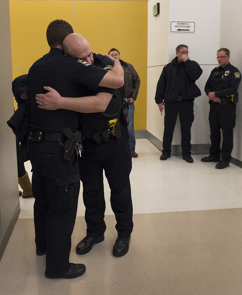 University of Colorado-Colorado Springs Lt. Clayton Garner, facing camera, hugs Lt. Marc Pino after a moment of silence for fallen officer Garrett Swasey before a college basketball game Saturday, Nov. 28, 2015, in Colorado Springs, Colo. Swasey was killed in a shooting at a Planned Parenthood Clinic in Colorado Springs on Friday. (Christian Murdock/The Gazette via AP)