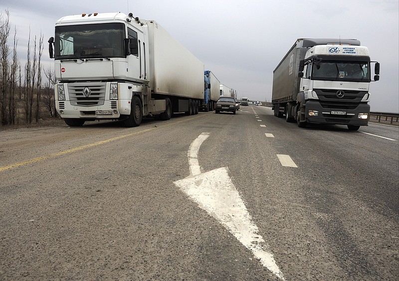 
              Several trucks stand on the sidelines as another drives past to take part in a demonstration, on the outskirts of Moscow outside Volgograd, Russia, Sunday, Nov. 29, 2015. Russian truck drivers have been protesting across the country, and one of their leaders says hundreds of trucks are now heading toward Moscow to press their demands. The truck drivers, many of whom own and operate their own vehicles, are protesting the introduction of a hefty road tax for long-distance haulers. (AP Photo/Dmitry Rogulin)
            