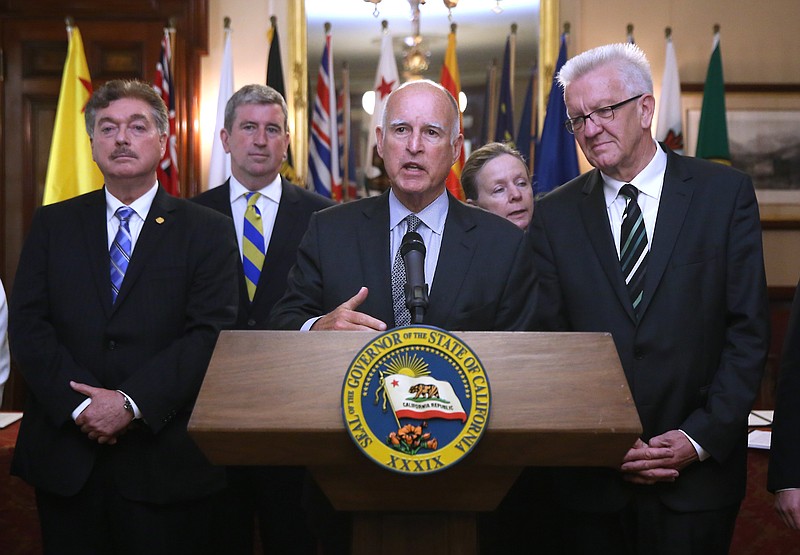 
              FILE - In this May 19, 2015 file photo, California Gov. Jerry Brown, center, discusses the non-binding climate change agreement he signed with international leaders from various states and provinces during a ceremony in Sacramento, Calif.  Brown will travel to the U.N. Climate Change conference to promote California's efforts to curb greenhouse gas emission and urge other governments to sign on to his climate pact. Brown was accompanied by Baja California Gov. Francisco A. Vega de Lamadrid, left, Ontario,Canada Minister of the Environment and Climate Change Glen Murray, second from left, and Baden-Wurttemberg Minister-President Winfried Kretschmann,right, with interpreter Olivia Reinshagen-Fernandez, second from right. (AP Photo/Rich Pedroncelli,file)
            