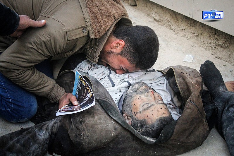 
              In this photo provided by the Syrian anti-government activist group Ariha Today, which has been authenticated based on its contents and other AP reporting, a Syrian man weeps on the body of a victim who was killed by airstrikes believed to be carried out by Russian warplanes in the center of Ariha town in the northwestern province of Idlib, Syria, Sunday, Nov. 29, 2015. Syrian opposition media is reporting that airstrikes believed to be carried out by Russian warplanes have killed and wounded dozens of people in a northwestern Syrian market. (Ariha Today via AP)
            