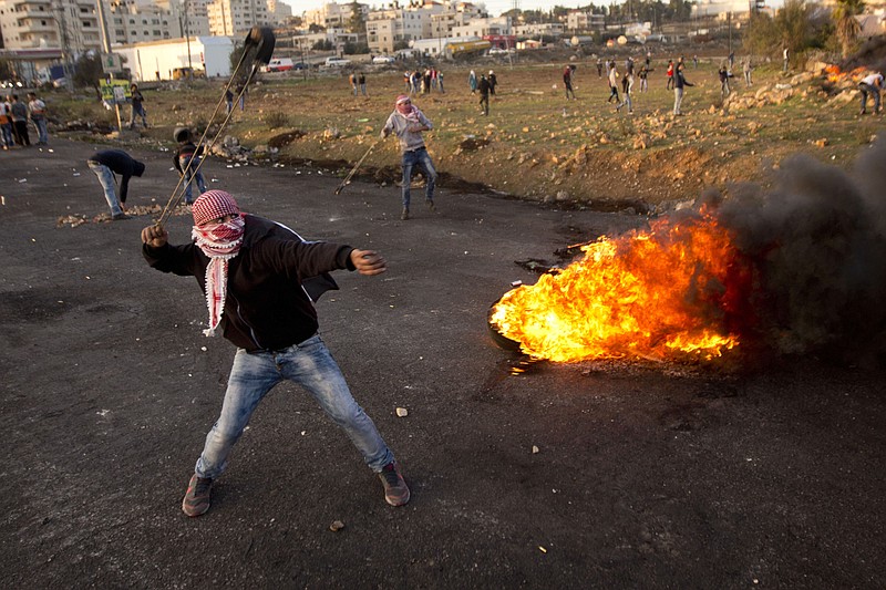 
              Palestinian protesters throw stones at Israeli troops during clashes following a demonstration to demand the release of bodies of Palestinian attackers by held by Israeli authorities, in the West Bank city of Ramallah, Sunday, Nov. 29, 2015. (AP Photo/Majdi Mohammed)
            