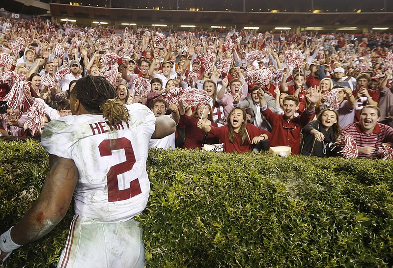 Alabama tailback Derrick Henry celebrates with fans after Saturday's 29-13 win at Auburn, which was the ninth straight victory for the Crimson Tide.