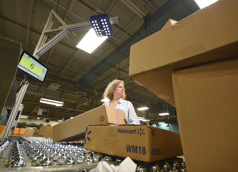 An overhead scanner identifies packages as postal clerk Rebecca G. Turner directs packages down different conveyor lines from the center of the "spider" inside the Chattanooga Postal Processing Center on Shallowford Road. "They call it that because it's got all these legs that come off of it," plant manager Jim Corkern said. 