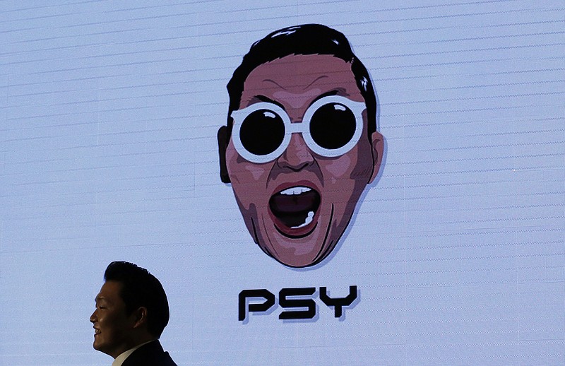 
              South Korean singer PSY walks past his own caricature shown on the screen during a news conference on the release of his seventh album in Seoul, South Korea, Monday, Nov. 30, 2015. PSY has become globally famous with his 2012 hit song "Gangnam Style," which shattered YouTube viewing records. (AP Photo/Lee Jin-man)
            