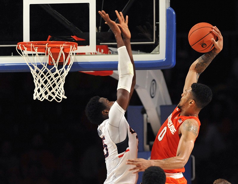 
              FILE - In this Nov. 26, 2015, file photo, Syracuse forward Michael Gbinije (0) takes the ball to the basket as Connecticut center Amida Brimah (35) defends during an NCAA college basketball game in the semifinals of the Battle 4 Atlantis in Paradise Island, Bahamas. There are five newcomers in the men's AP T25 poll with Syracuse being the highest at 14th. (Brad Horrigan/Hartford Courant via AP, File) MANDATORY CREDIT
            