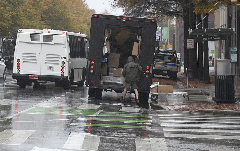 A UPS driver unloads packages in the bike lanes on Broad Street on Monday, Nov. 30, 2015, in Chattanooga, Tenn. After a grace period, the Chattanooga Parking Authority will begin ticketing businesses and vehicles that violate the new downtown bike lane policy. 