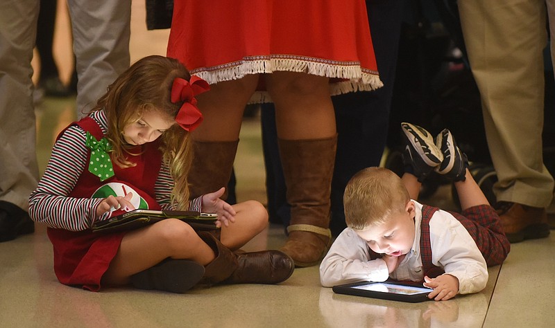 Chloe, left, and Jackson Brown use their tablets Tuesday, December 1, 2015 before a holiday celebration at Erlanger Hospital. Their brother, Aiden, was introduced as one of Erlanger's Miracle Children.