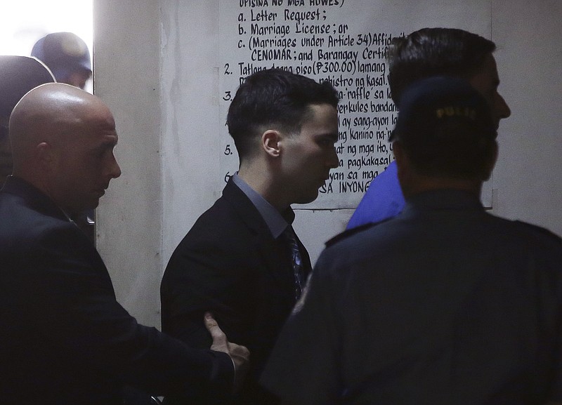 
              U.S. Marine Pfc. Joseph Scott Pemberton, center, the suspect in the killing of Filipino transgender Jennifer Laude, is escorted inside a court at Olongapo city, Zambales province, northwest of Manila, Philippines on Tuesday Dec. 1, 2015. A Philippine court is expected to deliver its verdict Tuesday in the emotion-charged case of a U.S. Marine accused of murdering a transgender Filipino after discovering her gender when they checked into a hotel, officials said.(AP Photo/Aaron Favila)
            