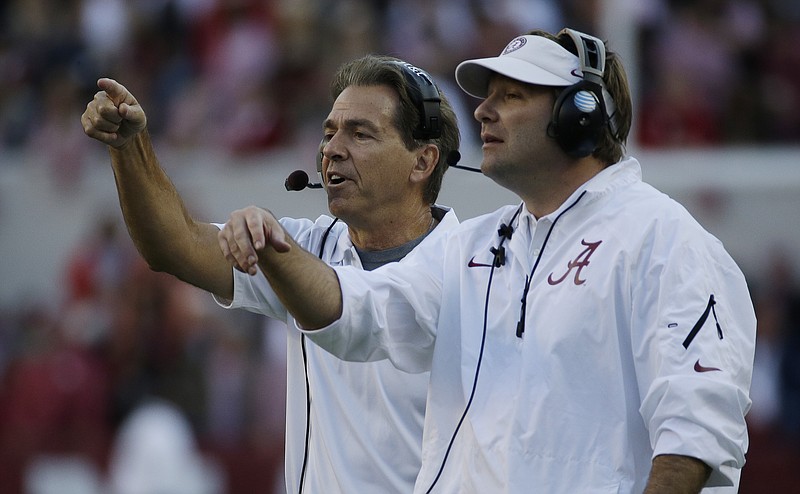 Alabama head coach Nick Saban, left, and defensive coordinator Kirby Smart call in a defense during the second half of an NCAA college football game against Tennessee in Tuscaloosa, Ala., Saturday, Oct. 26, 2013. (AP Photo/Dave Martin)