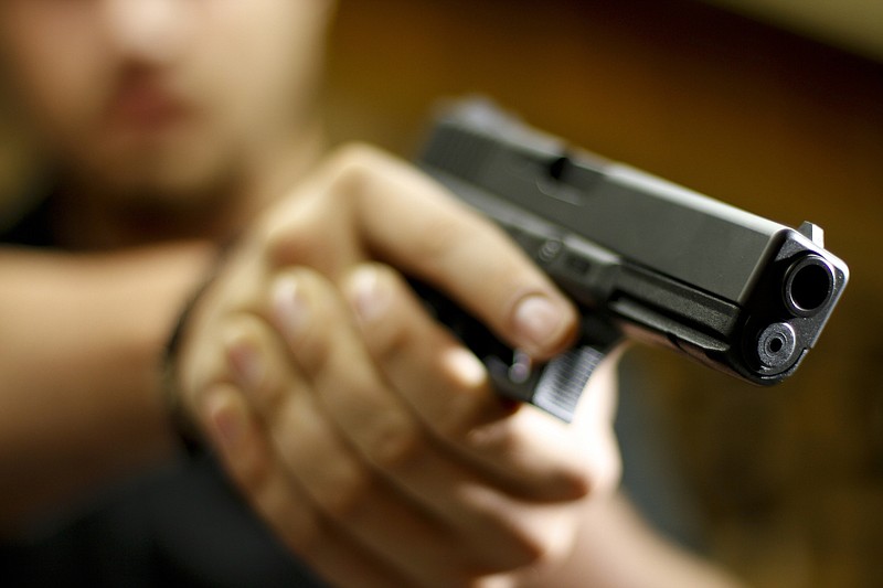 Staff Photo by Dan Henry / The Chattanooga Times Free Press- 8/14/14. Trentyn Murrell (CQ), a sales associate at Shooter's Depot, holds a Glock 9mm semi-automatic handgun inside of the store on August 14, 2014. According to recent data 9mm pistols are the most common handgun confiscated by Tennessee Police Departments. 