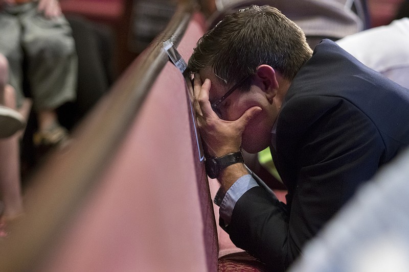 Chad Harris bow his head during a prayer vigil at Redemption Point Church following the shooting that left five dead in Chattanooga on July 16.