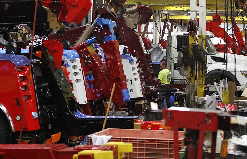 Employees put together massive trucks in the wrecker assembly shop at Ooltewah's Miller Industries.