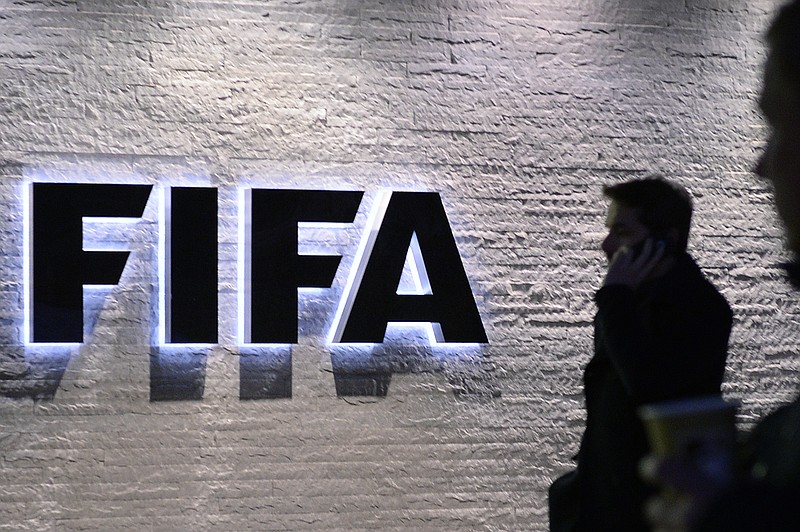 
              In this Dec. 2, 2015 photo a man stands in front of the logo at the FIFA headquarters "Home of FIFA" in Zurich, Switzerland. (Walter Bieri/Keystone via AP)
            