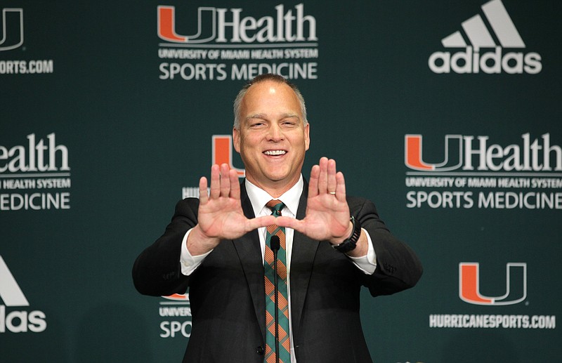 New University of Miami football coach Mark Richt flashes the "U" symbol during Friday's introductory news conference in Coral Gables, Fla.
