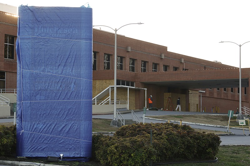 Staff Photo by Dan Henry / The Chattanooga Times Free Press- 12/4/15. Workers wrap the signage and board up the former Emergency Room entrance at Hutcheson Medical Center in Fort Oglethorpe, Ga., on Friday, December 4, 2015. 