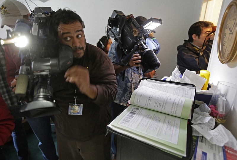 
              Members of the media crowd into the apartment bedroom of San Bernardino shooting suspects Syed Farook and his wife, Tashfeen Malik, in Redlands, Calif., Friday, Dec. 4, 2015, after the building landlord invited journalists into the townhouse. A book containing passages from the Quran is seen at right.  (AP Photo/Chris Carlson)
            