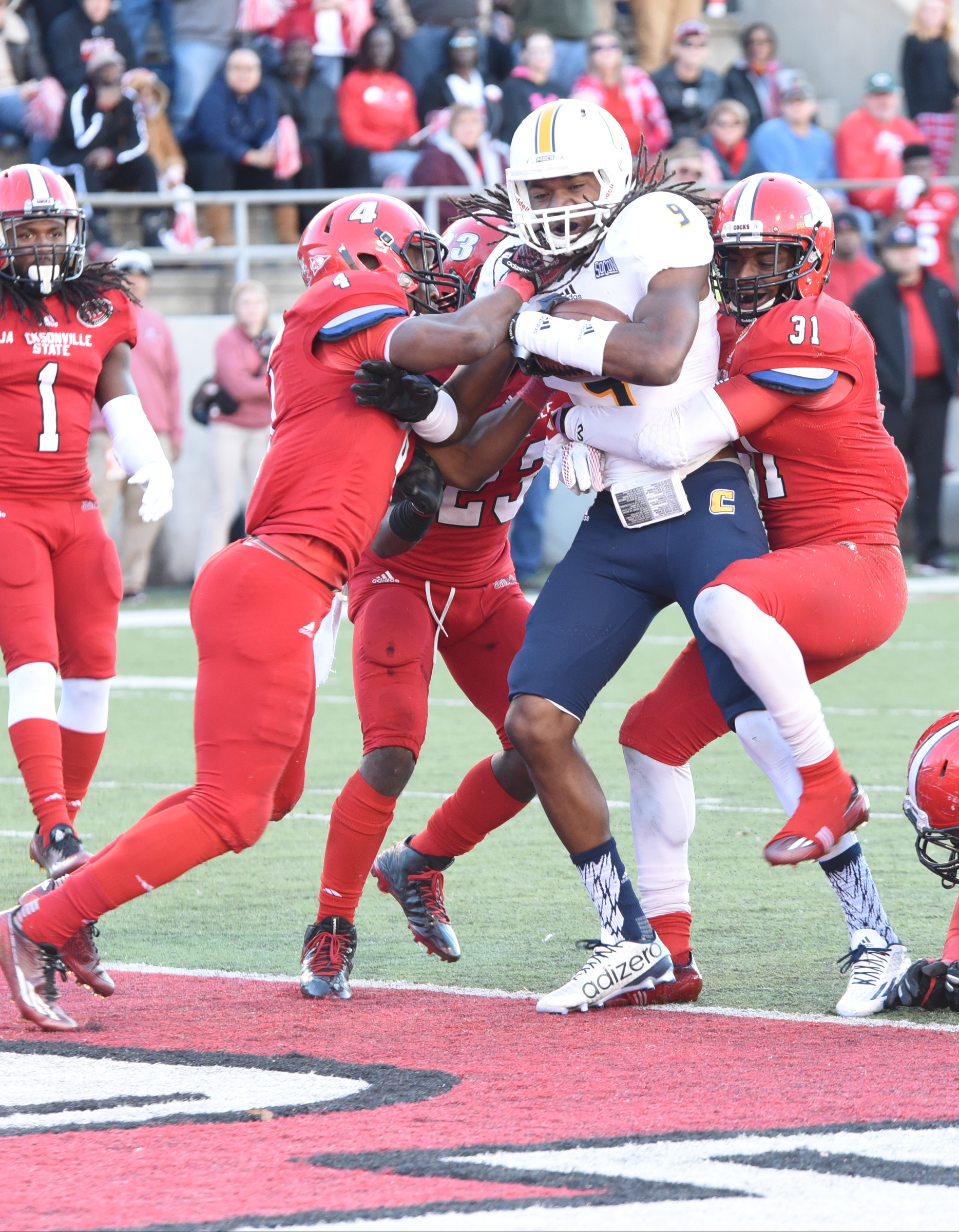UTC's Alphonso Stewart (9) crosses the goal line for a touchdown in the arms of three Jacksonville State defenders.
