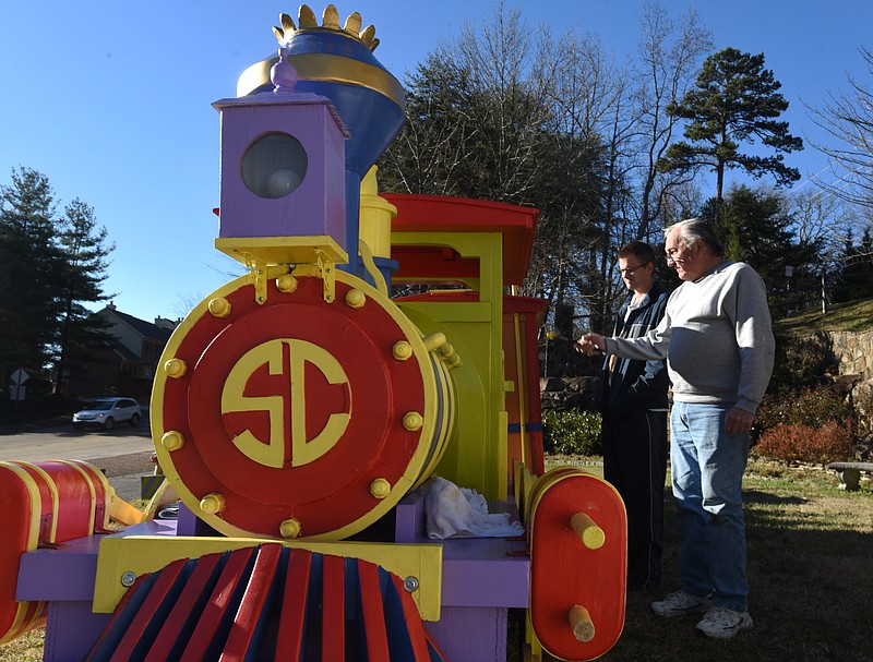 Signal Mountain Lions Club members Ken Abel, right, and Jay Casavant check out the wooden train while touching up paint on Friday, December 4, 2015, on Signal Mountain. The Lions Club has been repairing the train, which has suffered from the elements, and the locomotive was rebuilt this year.