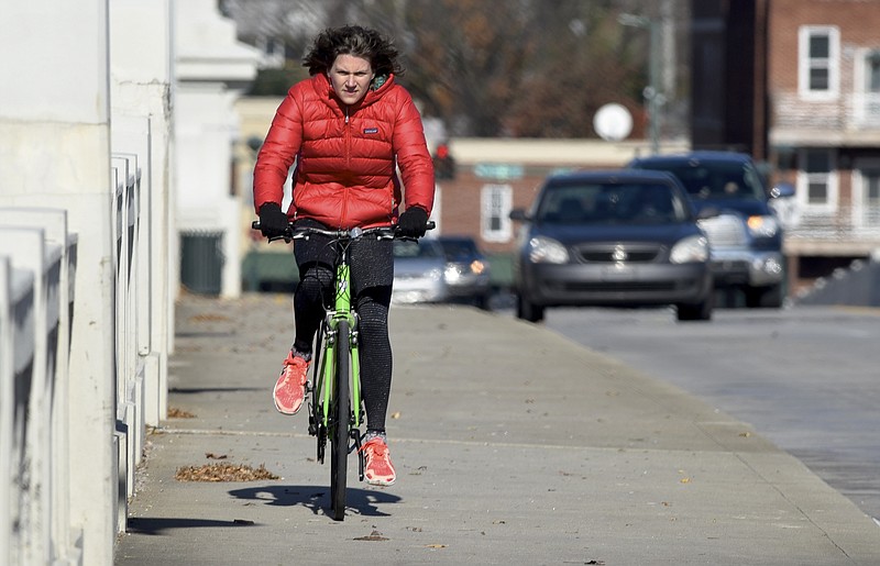 Robyn Fogle (CQ) rides her bicycle on the sidewalk on the Market Street Bridge on Thursday, Dec. 3, 2015, in Chattanooga, Tenn. The city's bike safety program is nearly a year old, and coincides with a significant reduction in accidents between bicycles and cars. 