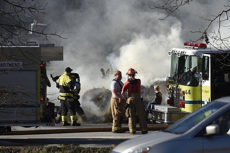 Firefighters work to extinguish a fire on a trailer load of hay at the truck pull-off on I-75 southbound near mile marker 13 just north of the Ooltewah community on Tuesday, Dec. 8, 2015, in Chattanooga, Tenn.