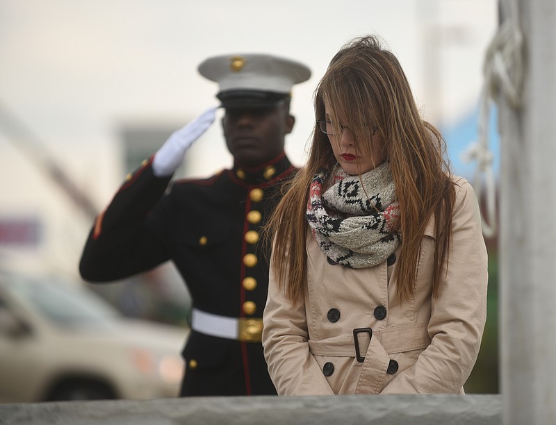 Angie Smith, right, widow of Navy Petty Officer 2nd Class Randall Smith, and Sgt. Demonte Chieeley listen as Taps is played Wednesday, December 9, 2015, at the Lee Highway memorial